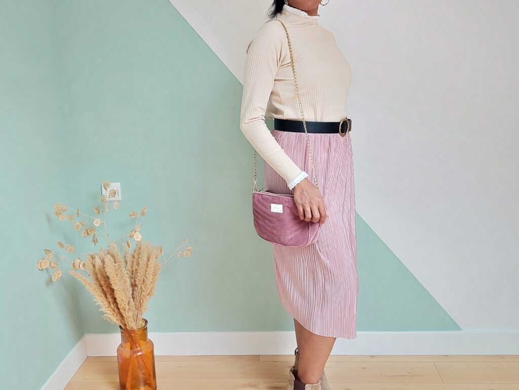 Sous-pull Romantica beige vue de côté portée avec une jupe plissée rose